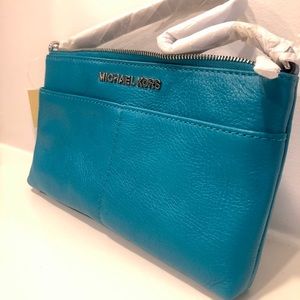 Never used Michael Kors Aqua wristlet 5 in x 9 in two pockets on the outside